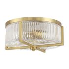 The Whittley 60183-SB flush mount ceiling light by Craftmade features a gold circular frame, ribbed glass shade, and geometric accents, offering an elegant and modern appearance similar to Whittley chandeliers.