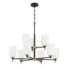 The Council - 60329-FBSB chandelier features a black metal frame with eight white cylindrical lampshades arranged in a circle. Its suspended by a chain and includes satin brass accents that connect the lampshades to the frame elegantly.