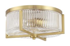 The Whittley 60183-SB flush mount ceiling light by Craftmade features a gold circular frame, ribbed glass shade, and geometric accents, offering an elegant and modern appearance similar to Whittley chandeliers.